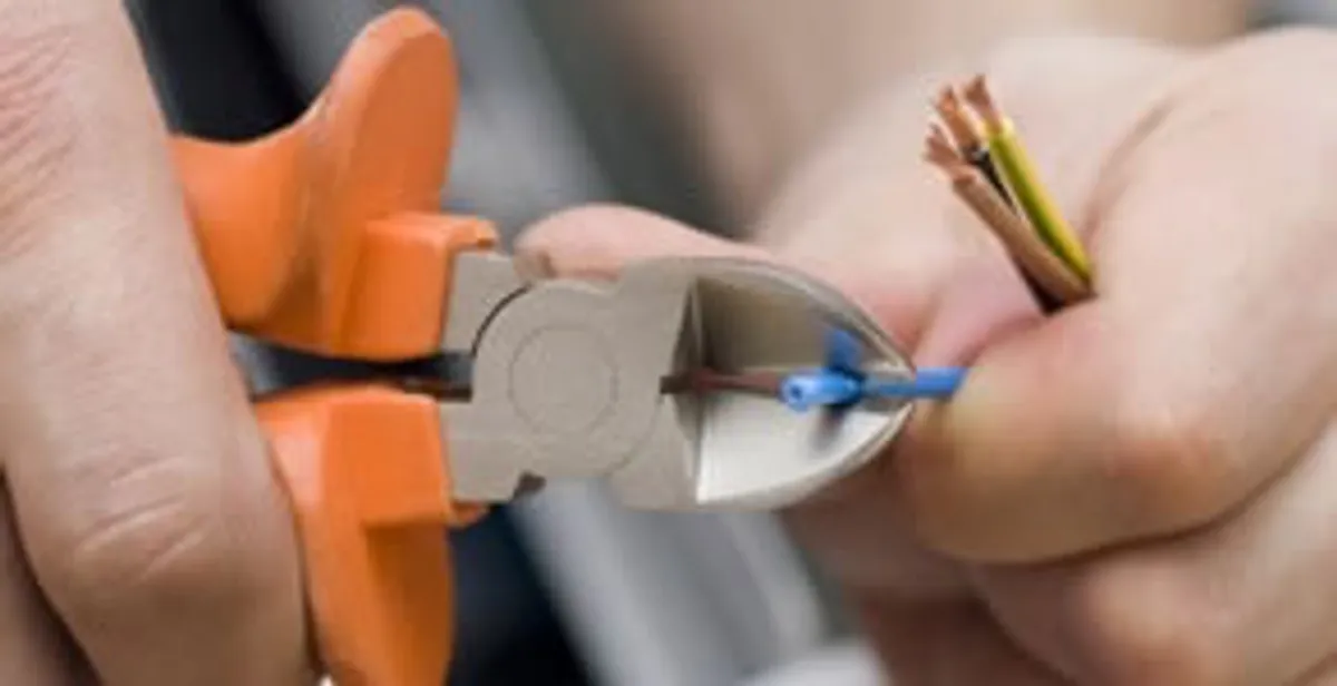 licensed electrician performing precise wire cutting and preparation during electrical service in Boise, ID